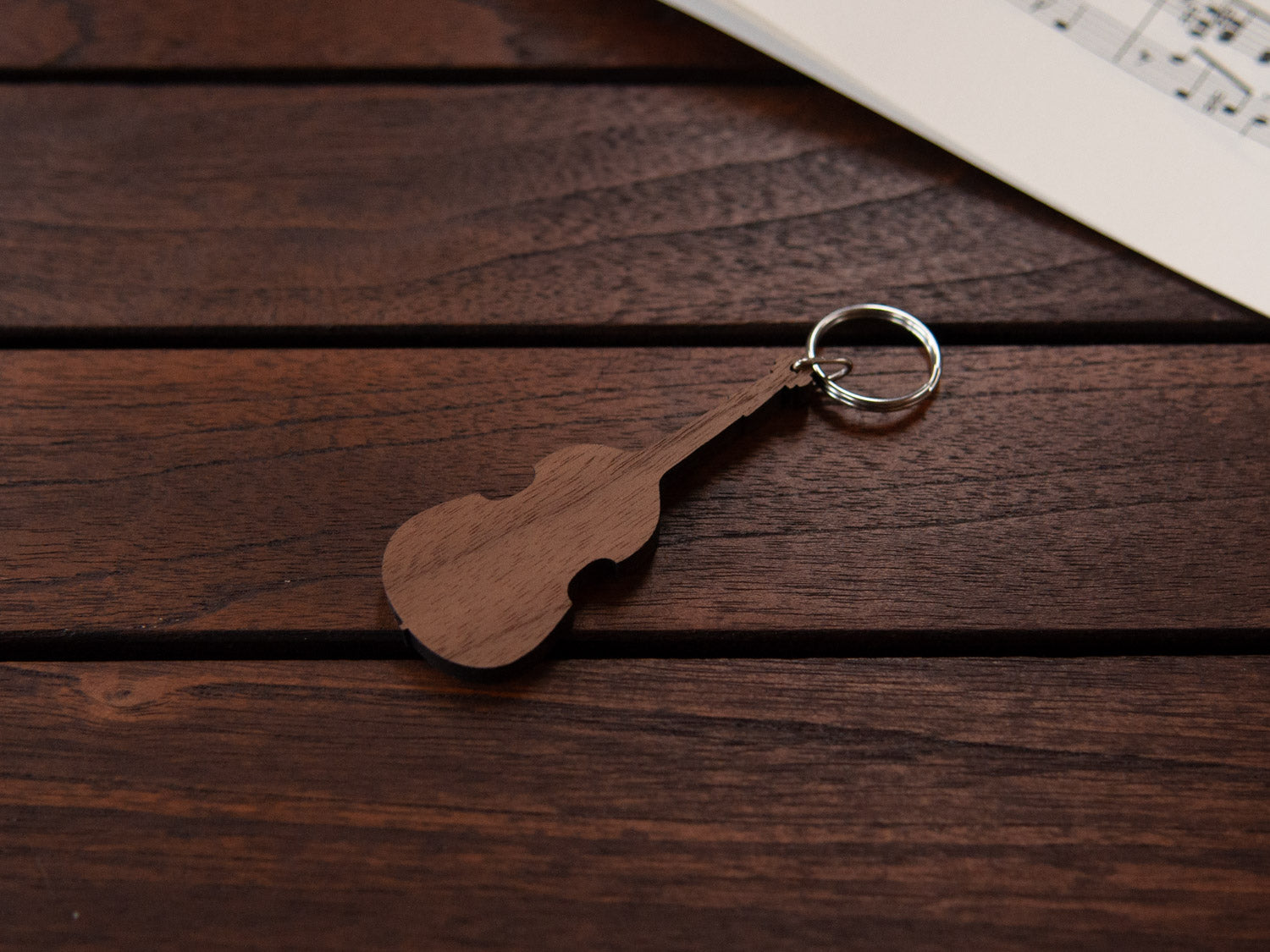A double bass shaped keychain made from walnut wood