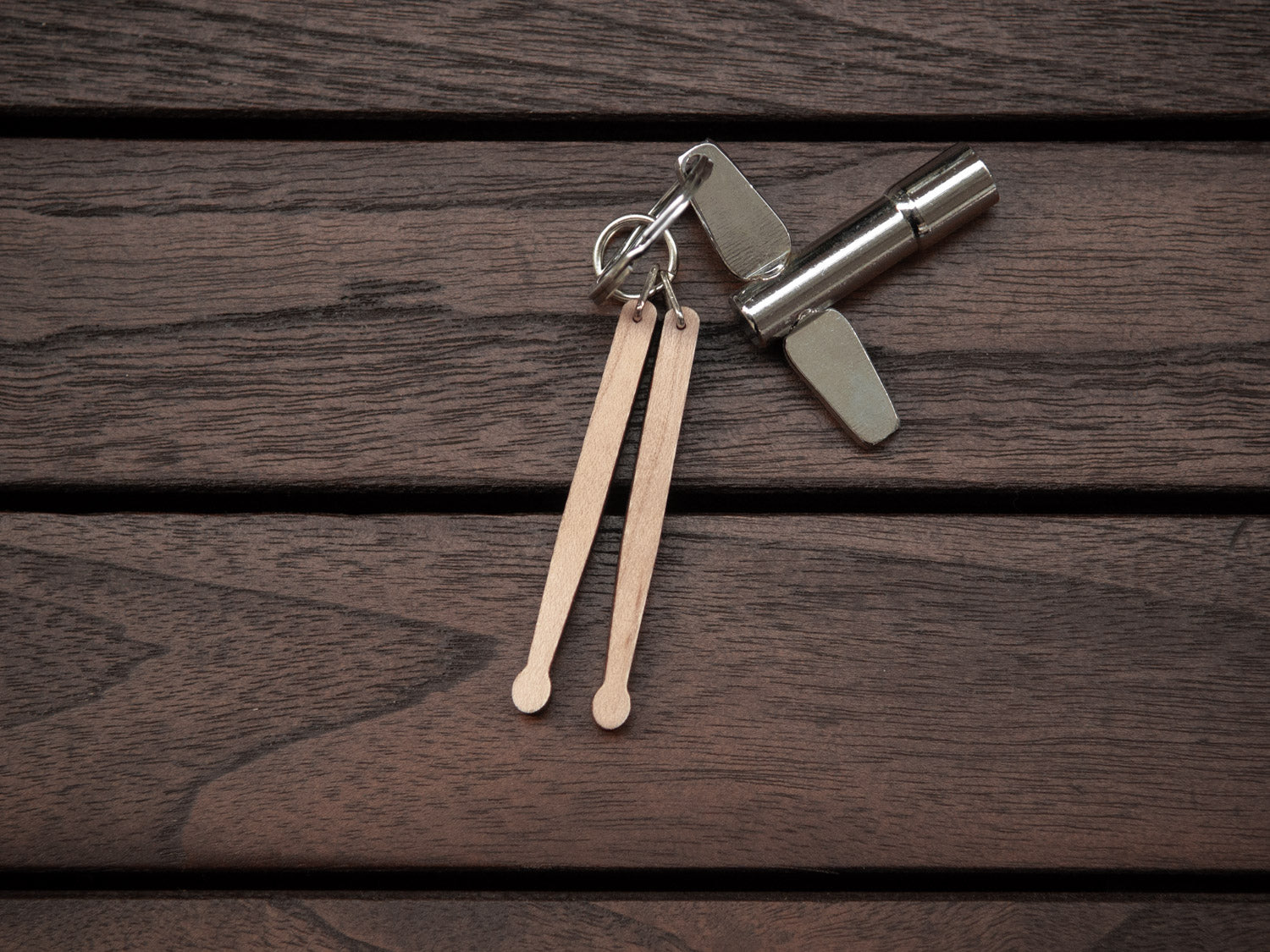 Keychain in the shape of drumsticks, made from maple wood. A drum key is also attached to the key ring.