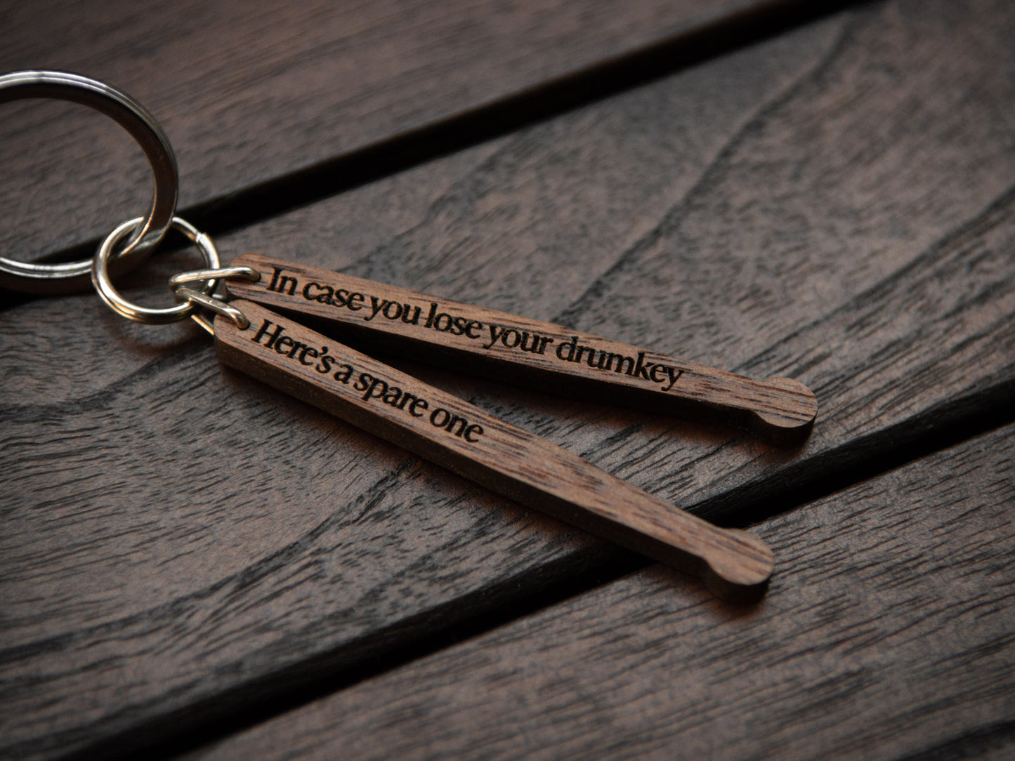 Detail of engraving on drumstick keychain, made from walnut wood.