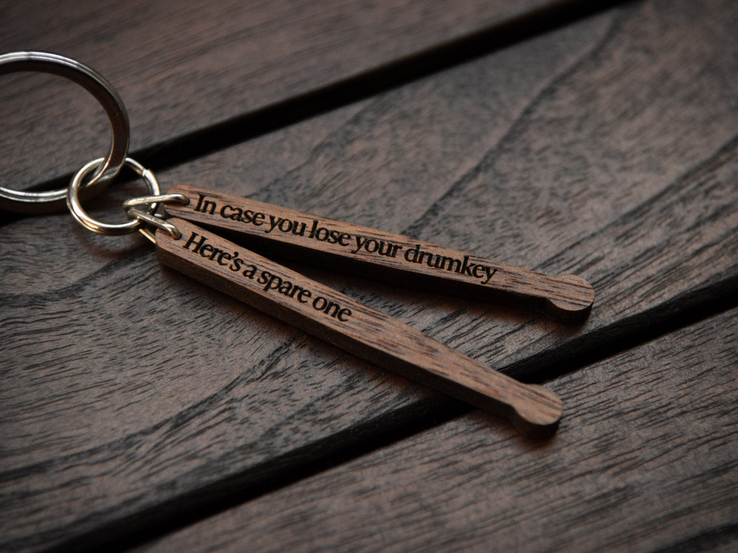 Detail of engraving on drumstick keychain, made from walnut wood.
