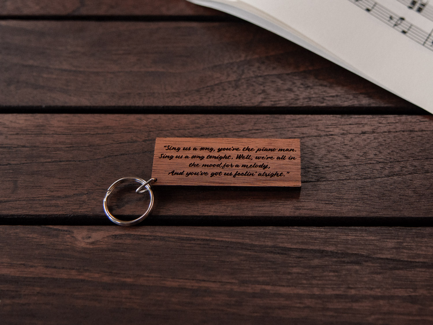 The backside of a piano keychain made from walnut wood, with custom engraving